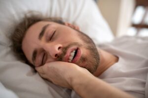 young-man-sleeping-in-his-bed-in-the-morning-2024-10-16-23-01-10-utc - Synergy Dental