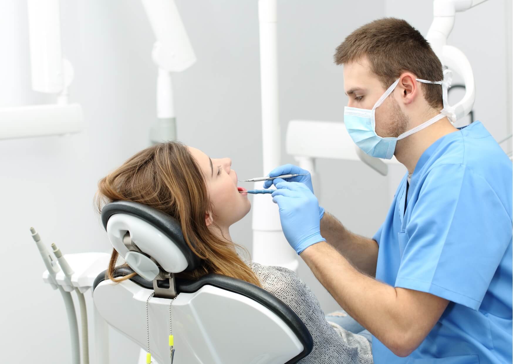 Dentist examining a patient's teeth during a first dental appointment to assess oral health and create a personalized treatment plan