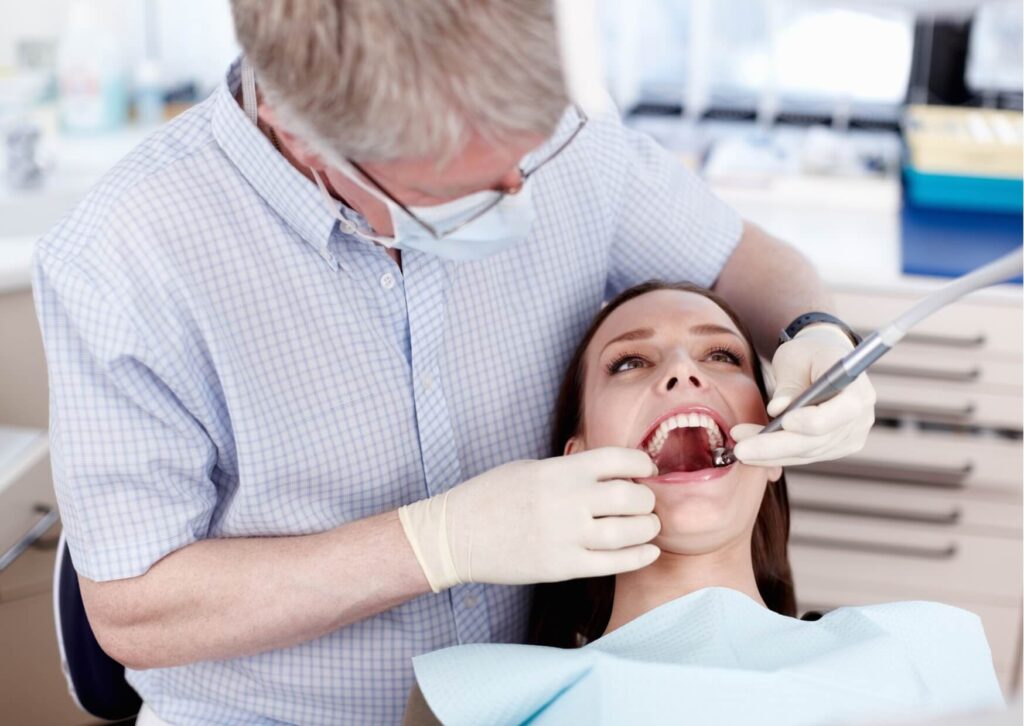 Dentist examining a patient's teeth during a checkup to evaluate oral health changes that may occur while taking Ozempic.